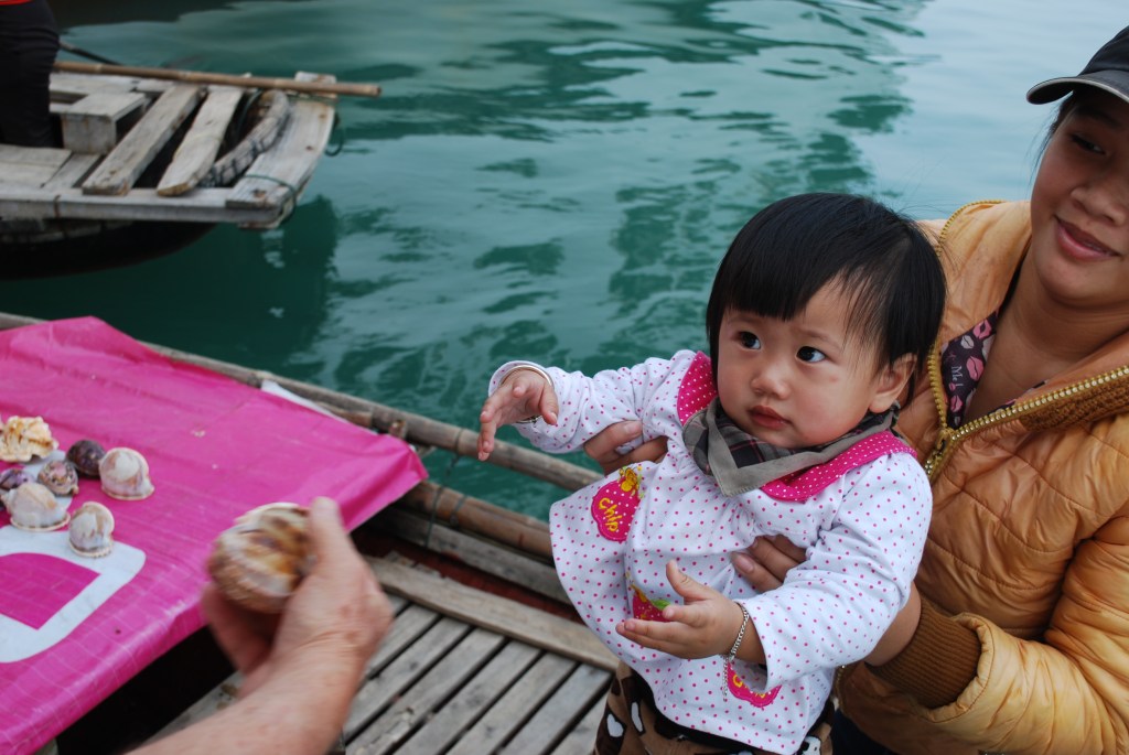 Little girl and her mother selling sea shells