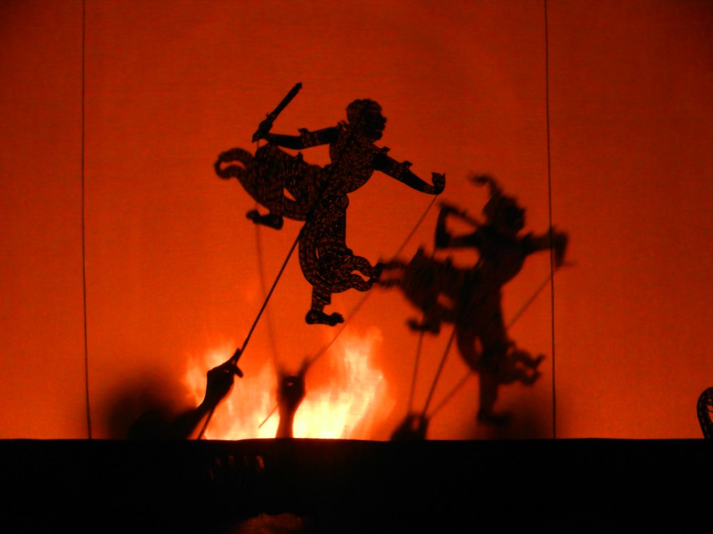 Two shadow puppets duelling
